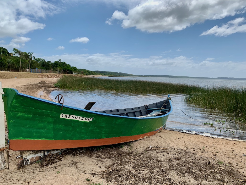 barco na areia em frente à lagoa