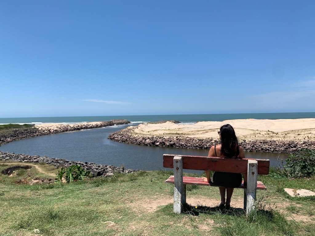 Arroio Chuí, um banco, uma pessoa, pedras e areia