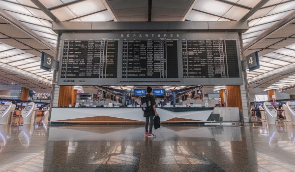 passageiro verifica voo no painel do aeroporto