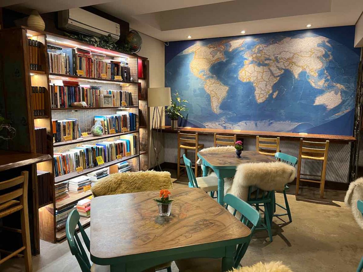 O que fazer em São Leopoldo: o work hotel possui papel de parede de mapa mui e uma estante recheada de livros