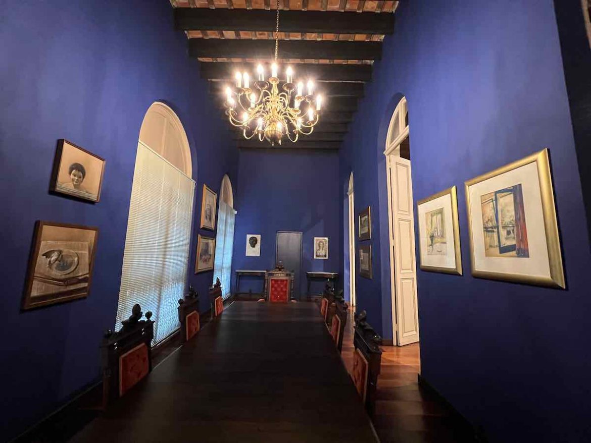 O que fazer em Novo Hamburgo: há uma sala de jantar cheia de quadros, com paredes na cor azul e um lindo lustre