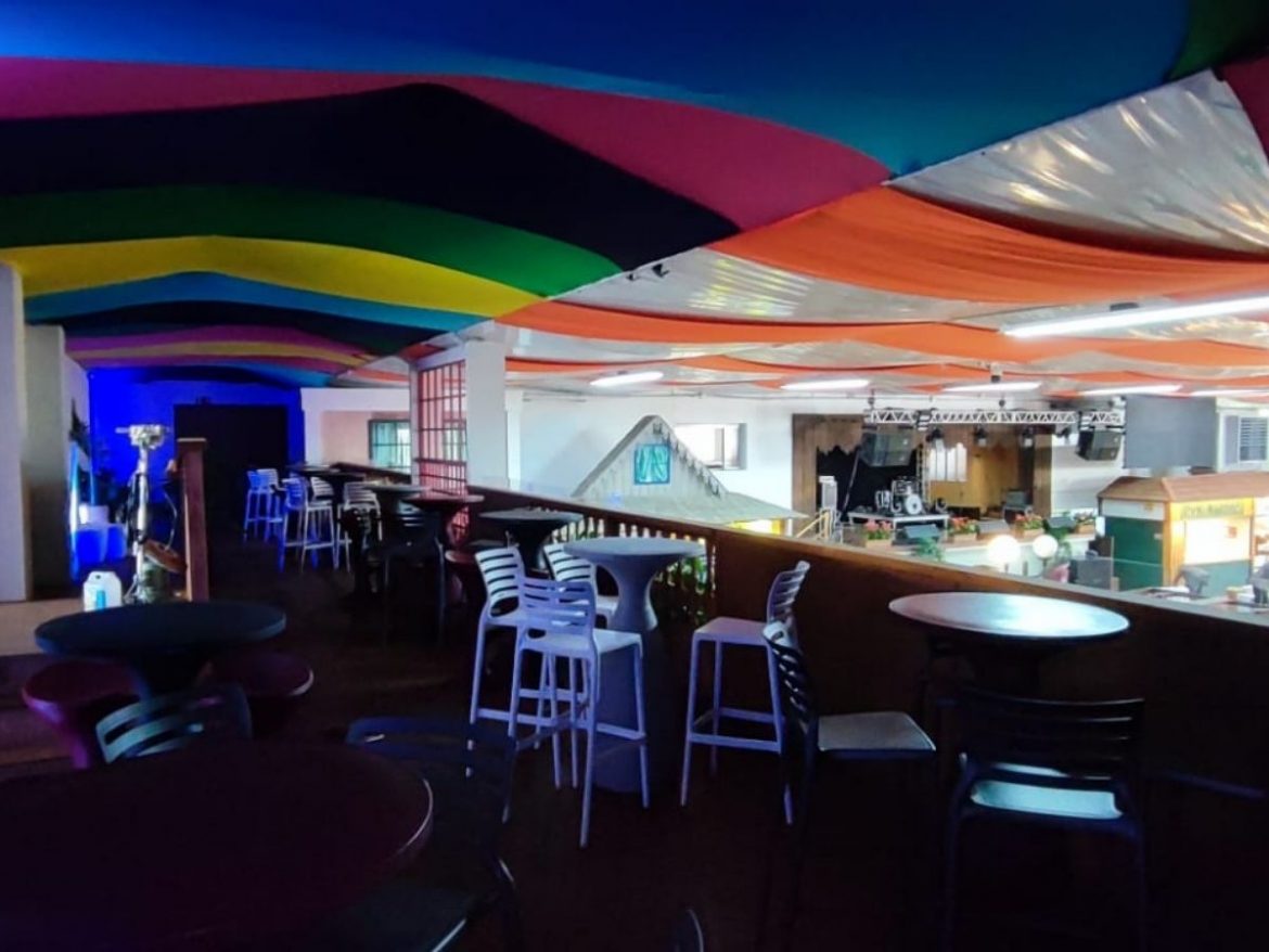 Festiqueijo 2022: na foto está o mezanino da área vip, com mesas e cadeiras e um teto colorido